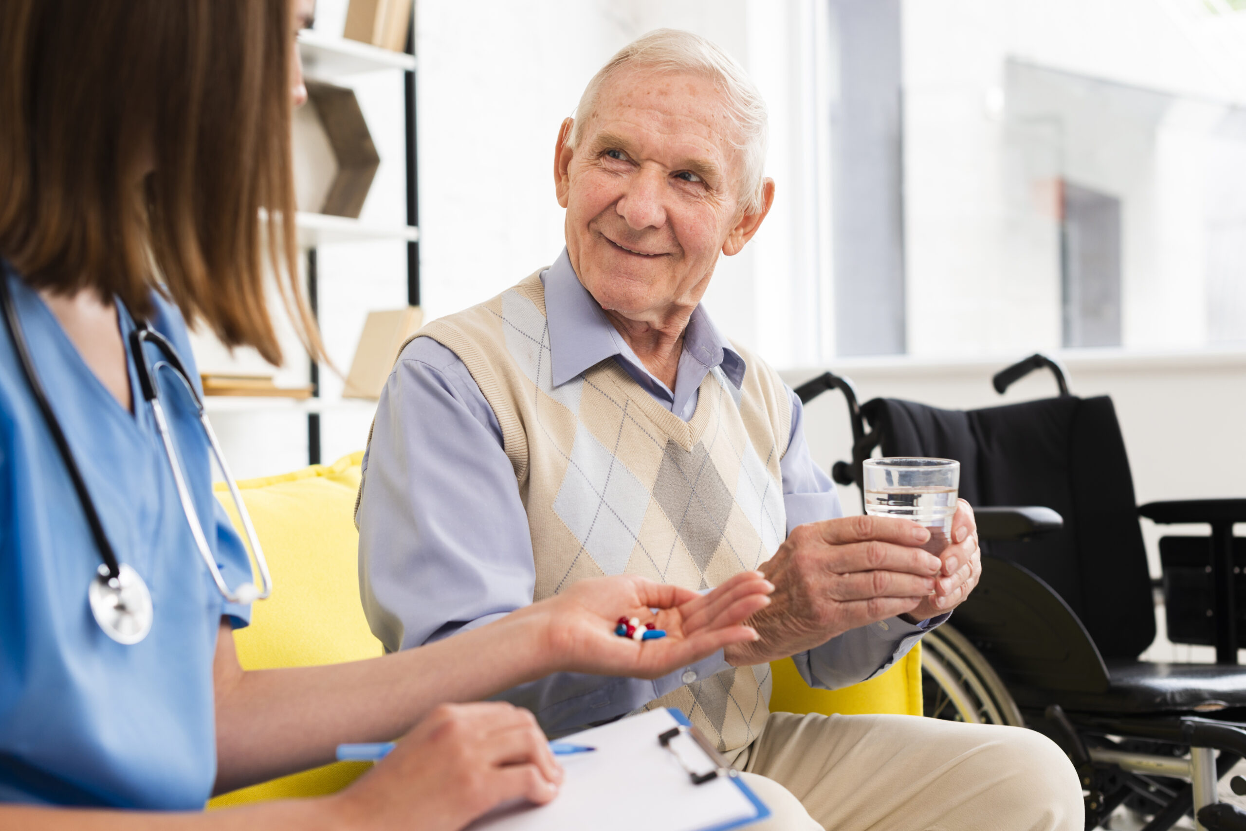 Nurse providing medication assistance to an elderly man at home, emphasizing the value of home healthcare with a glass of water and a warm smile.